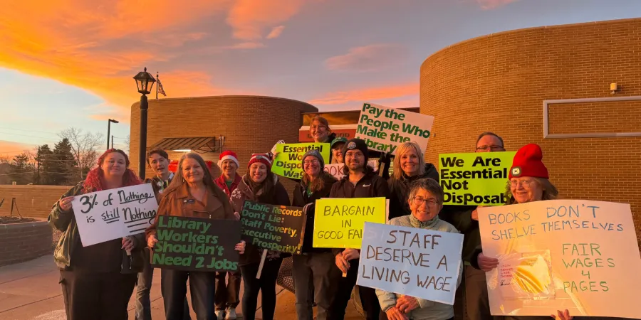 Union members holding signs standing outside of their workplace